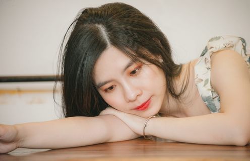 靠在棕色桌子上的女人