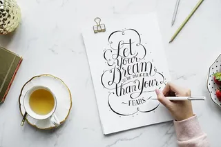 在白色海报附近拿着白色钢笔的人