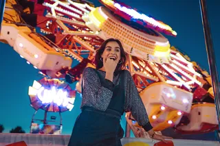 站在黄色骑行海报旁笑的女人