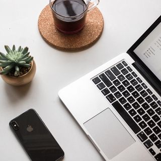 咖啡和多汁植物旁打开笔记本电脑旁的太空灰iPhone X 咖啡和多汁植物旁打开笔记本电脑旁的太空灰iPhone X