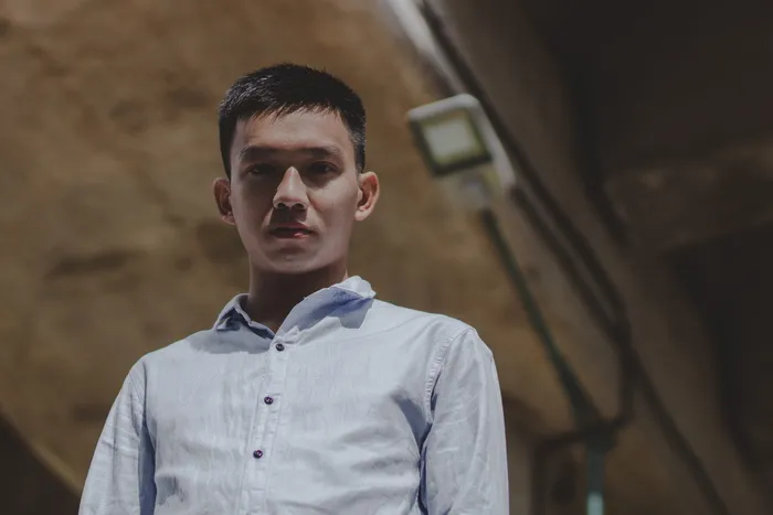 身穿白色衬衫的男子站在路灯下