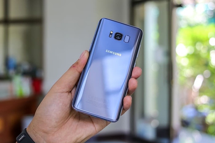 手持蓝色三星Galaxy S8的人