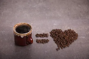 棕色陶瓷杯旁的咖啡豆