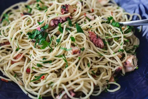 精美的晚餐，搭配海鲜意大利面、小龙虾和红酒，餐桌上装饰着玫瑰