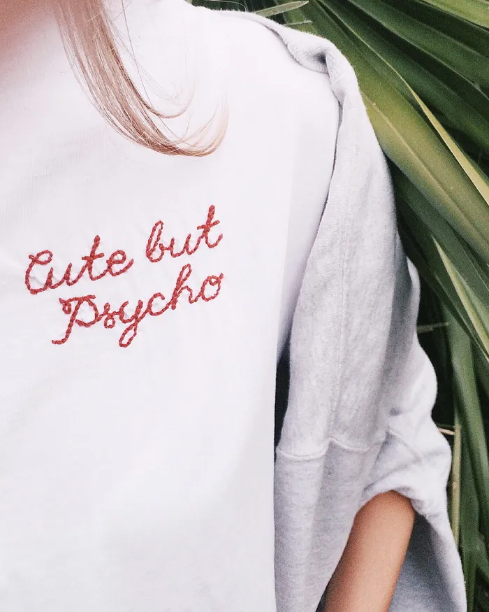 一位女士在绿叶旁穿白色毛衣