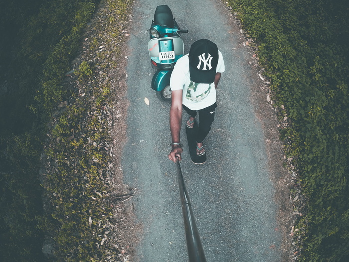 男子在绿色摩托车上拍照的航拍照片