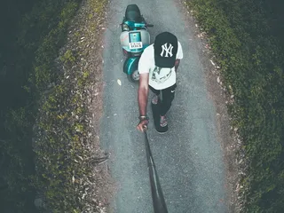 男子在绿色摩托车上拍照的航拍照片