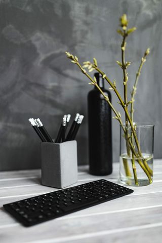 白色桌子上带铅笔的黑色键盘