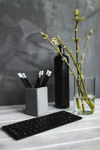 白色桌子上带铅笔的黑色键盘