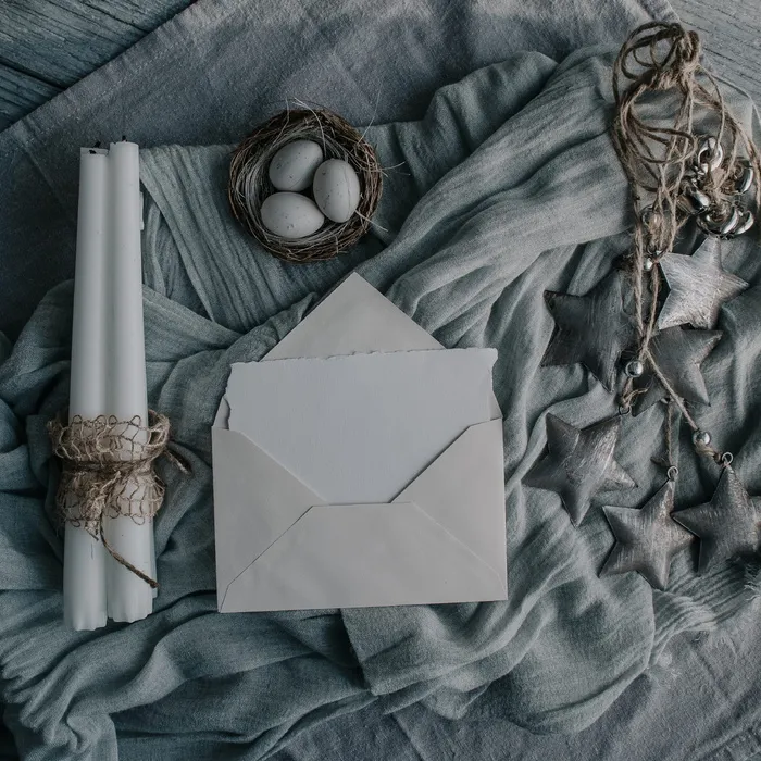 白色信封旁边的白色蜡烛棒