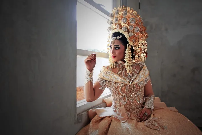 斜靠在窗户上穿着棕色露肩连衣裙的女人