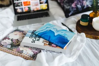 床上放满了枕头和带苹果小玩意的笔记本