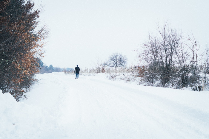 一名男子在被雪覆盖的土路上行走