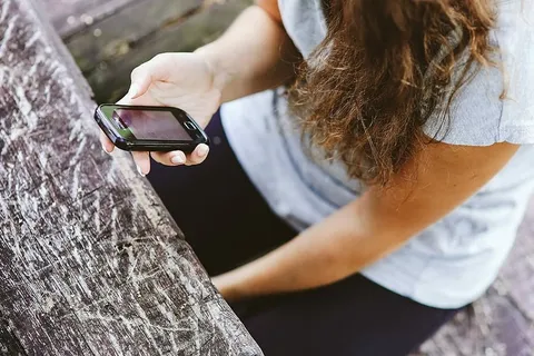 拿着白色手机的年轻女子