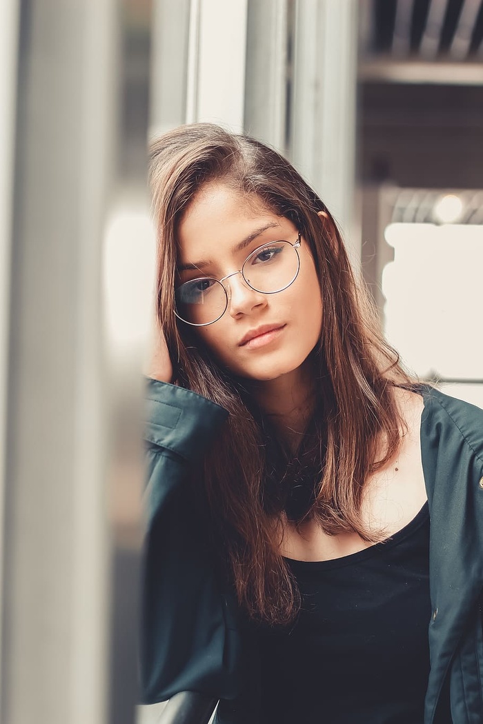 戴眼镜的女人靠在窗台上的照片