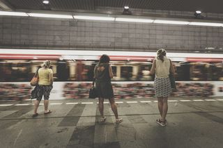 三个女人站在正在行驶的火车旁