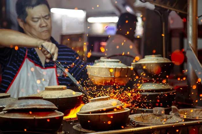 做饭时拿钳子的男子