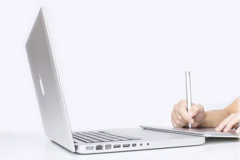 在MacBook前写作的人