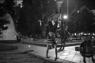 一个男人在公园里做手站的灰度照片