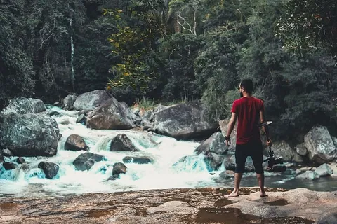 站在流动的河流前的男人