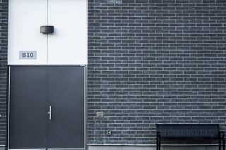 黑色金属长凳，黑色，长凳，门，墙，砖，砖墙，街道摄影