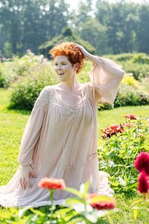 跪在百日草花旁的女人