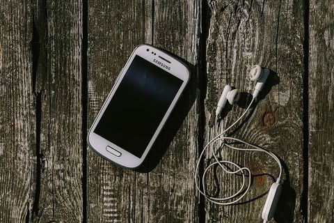 木质背景上有各种物品的白色智能手机