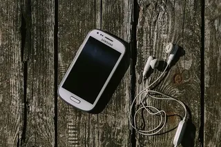 木质背景上有各种物品的白色智能手机