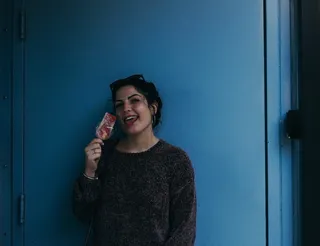 一名女子拿着冰激凌在棍子上吐舌头