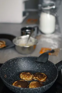 装满四个烤饼的黑色铸铁煎锅 装满四个烤饼的黑色铸铁煎锅