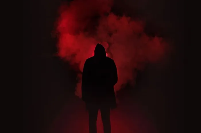站在黑色和红色背景下的男人剪影