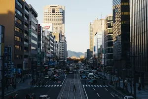 人们走在繁忙的街道上，靠近高楼大厦旁的不同车辆