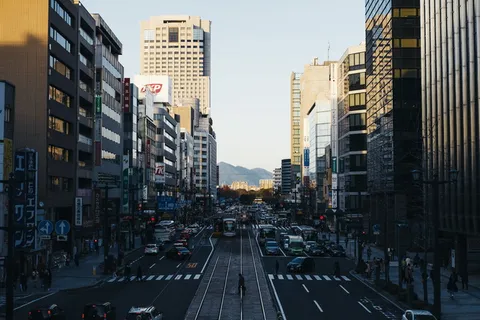 人们走在繁忙的街道上,靠近高楼大厦旁的不同车辆 人们走在繁忙的街道上,靠近高楼大厦旁的不同车辆