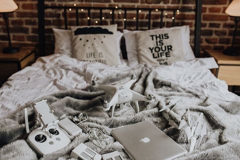 无人机、笔记本电脑和配件躺在床上准备旅行