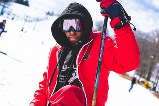 戴着谷歌眼镜拿着滑雪杆的男人