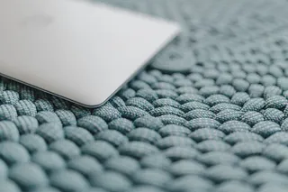 蓝色口袋上的MacBook笔记本电脑