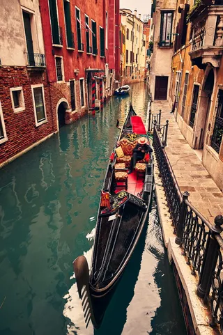 停靠在威尼斯大运河人行道边的船上的人