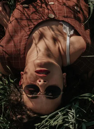 戴太阳镜躺在地上的女人