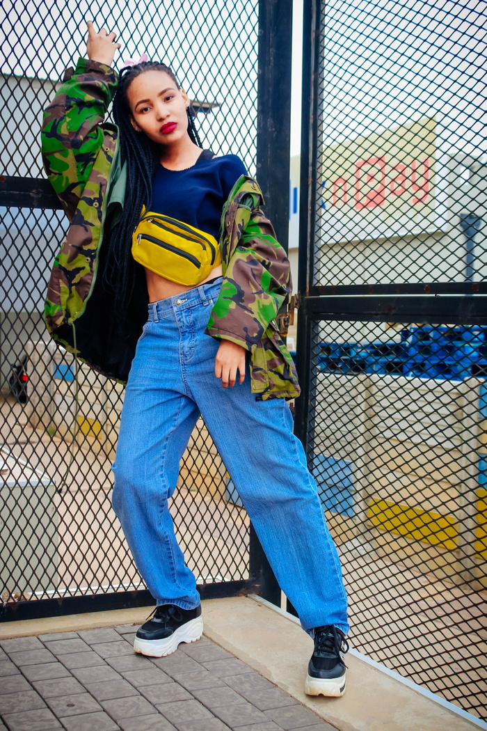 站在铁丝网围栏旁穿着牛仔服的女人