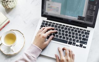 手持Macbook Pro的女性