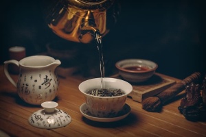把热水倒在茶杯上的金壶