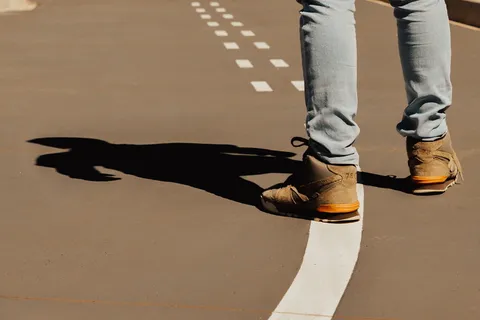 穿着棕色高帮运动鞋站在球场上的人