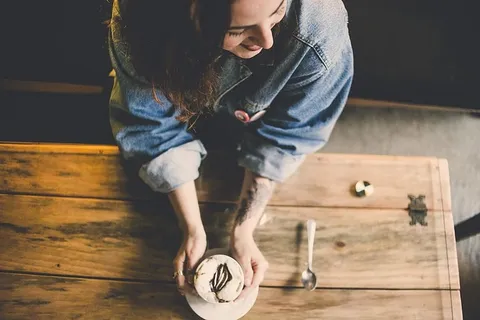 站在桌子旁边拿着蛋糕的女人