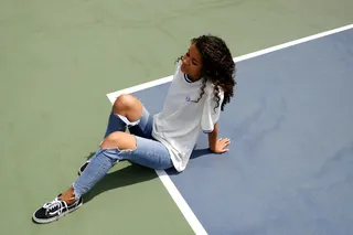 白天穿着白色衬衫和蓝色旧牛仔的坐着的女人