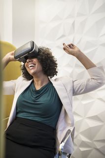 身穿白色正式外套、佩戴黑色Vr耳机的女士