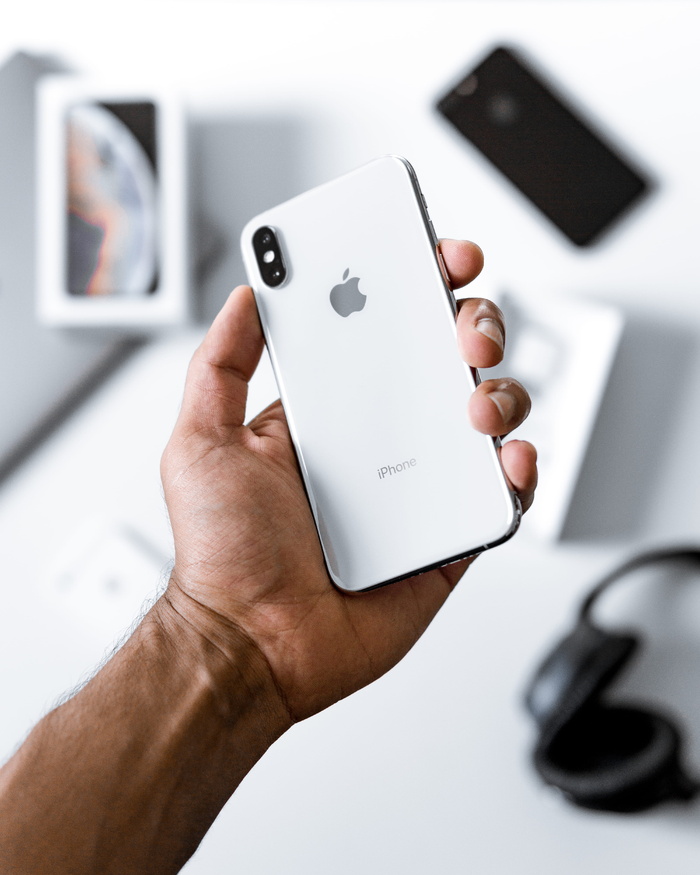 手持银色iPhone X的人