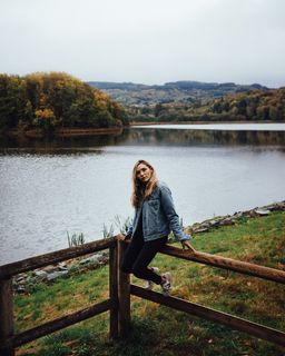 坐在棕色木栅栏上的女人