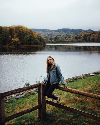 坐在棕色木栅栏上的女人