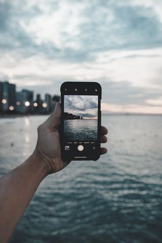 在水体附近拍照的人