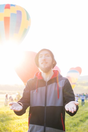 穿着套头衫连帽衫的男子站在热气球附近